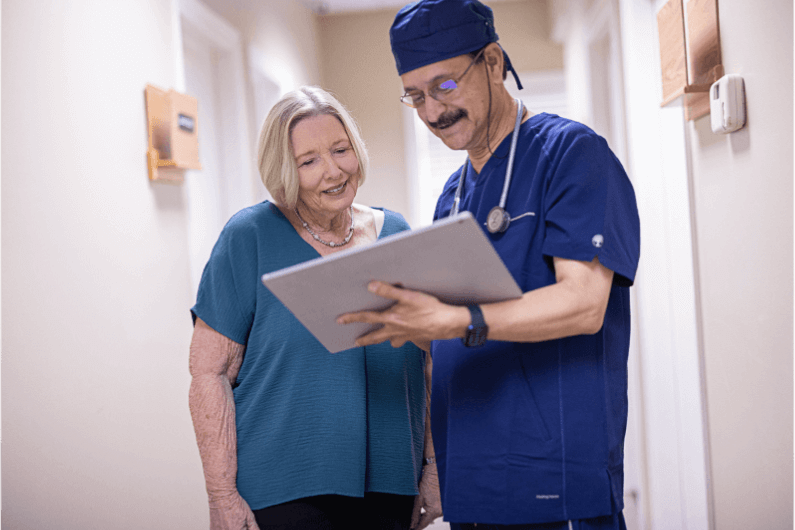 Arzt und Eversense Benutzerin sehen sich Glukosewerte für das kontinuierliche Diabetesmanagement an.