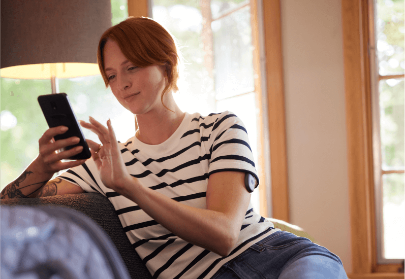 Eversense Benutzerin koppelt mit Smartphone und mobiler App den Transmitter und den Sensor.